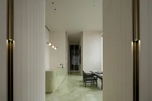 A minimalist kitchen with a white marble countertop and floor.