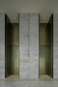 A modern lobby featuring glass elevator doors.