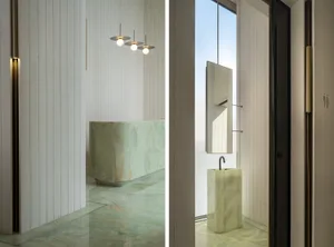 A modern bathroom with minimalist design, featuring marble fixtures and floor-to-ceiling windows.