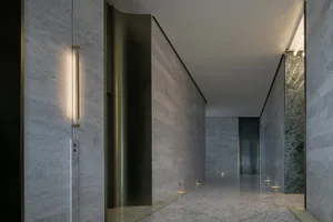 A modern marble corridor with integrated lighting on the walls and floor.