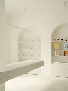 Minimalist retail storefront with concrete shelving and white products