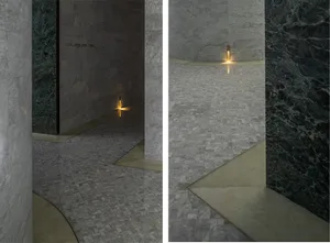 A minimalist interior design featuring marble floors and walls.