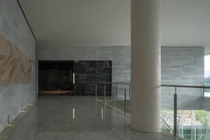 Modern office lobby with marble walls and concrete flooring.