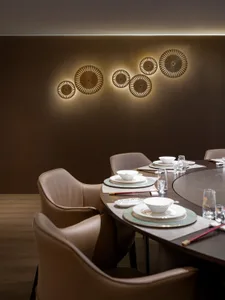 Modern dining room with round table and brown leather chairs, featuring wood and glass accents.