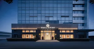 Modern, elegant hotel exterior with glass facade and concrete accents.