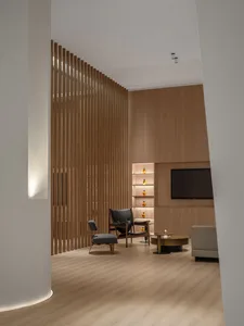 A modern interior design featuring a library room with wooden panels and shelves.