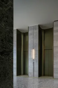 Modern lobby entrance featuring marble walls and vertical lighting fixture