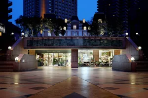 A retail storefront with glass windows, marble accents, and concrete flooring.