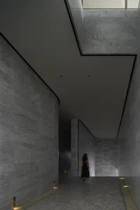 A modern interior space with marble walls and floors, featuring a minimalist design.