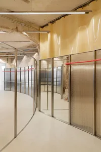 Interior of a modern retail exhibition space with concrete, metallic, and glass materials.