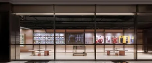 A modern retail storefront featuring advertisements on a large digital board.