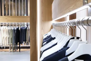 服裝店室內空間，搭配木製展示櫃與金屬衣架