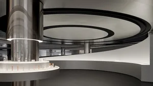 A modern retail storefront featuring a curved glass facade and metal elements.