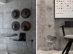 Industrial interior design featuring a raw concrete wall with textured patterns, a black chair, a modern table, and various d