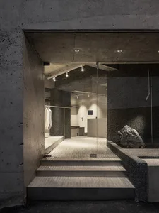 Minimalist industrial retail storefront with concrete and glass materials.