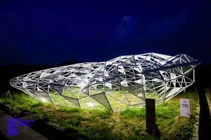 A minimalist metal installation against a dark, starry night sky.