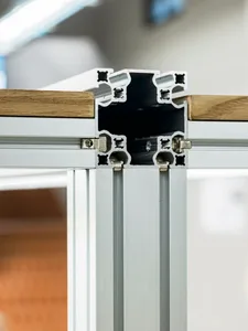 A close-up view of a modern aluminum frame assembly with wooden panels attached.