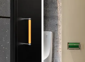 Modern bathroom with a black door featuring a bright yellow handle and a urinal in the background.