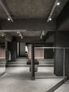 Interior of a modern clothing store with concrete walls and floor.