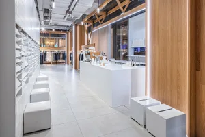 Modern retail store interior with minimalist design elements and white and wood finishes.