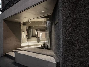 Concrete retail storefront with glass display windows and stone accents