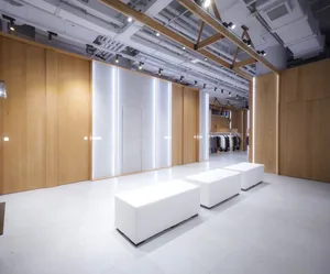 Modern retail storefront with white concrete walls and wooden accents.