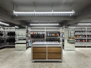 A minimalist retail store interior with metal and wood shelves, glass displays, and metallic accessories.