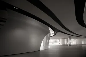 A modern interior space featuring a glass ceiling with an exhibit showcasing corporate history.
