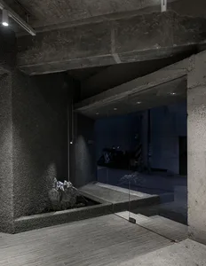 A modern entranceway featuring concrete and glass materials with a minimalist design.