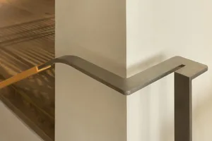 Modern staircase featuring steel railing and concrete steps