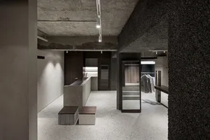 A modern industrial shoe shop with concrete floors, walls, and accents.