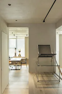 A minimalist office space featuring wood flooring and contemporary furniture.
