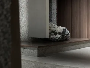 A modern industrial interior design featuring concrete and rock elements on the ground