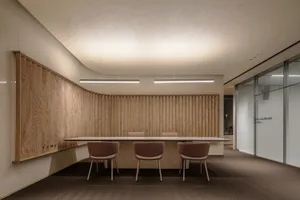 A modern minimalist conference room with wooden walls, marble accents, and contemporary lighting.