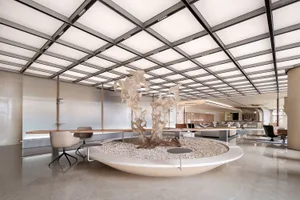 Contemporary office space featuring a glass wall with a sculptural element at the center.