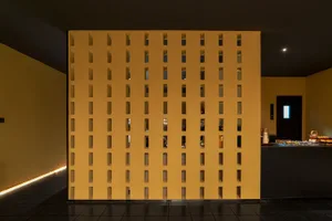 A modern living room with a wall of brick cubes for decoration.