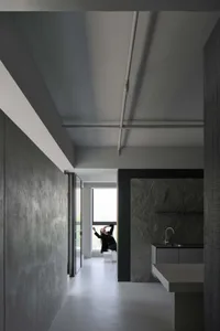 A minimalist modern living space featuring sleek, dark concrete walls and a minimalist design.