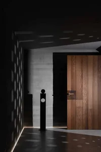 A minimalist interior featuring wooden materials and a black sculpture.