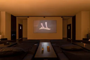 A cozy relaxation room featuring black textiles and a small table with a candle.