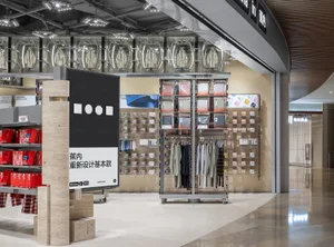 服飾店以金屬衣架與吊掛軌道陳列服裝，並搭配玻璃與混凝土元素。