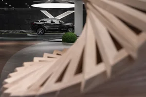 Modern car showroom interior featuring wood elements and a black SUV.