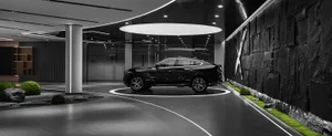 A black and white luxury car parked in a modern, minimalist lounge with concrete and glass materials