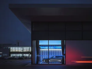 A modern automotive showroom with glass and metal architectural elements.