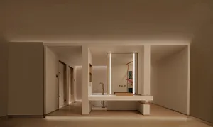 Modern minimalist bathroom with concrete walls and floor, featuring a sleek sink and large mirror.