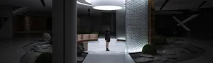 A modern lobby interior with glass walls, metal accents, and concrete flooring.