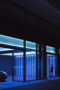 Modern minimalist entrance with glass walls and vertical lighting features.