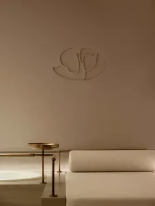Modern minimalist interior design featuring a metal accent and beige upholstery.