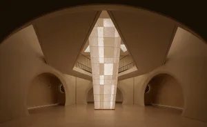 Modern office lobby with glass columns and arched doorways.