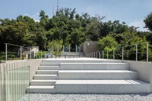 A modern park featuring concrete stairs surrounded by greenery and trees.