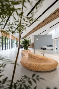 Interior of a modern car showroom with wooden seating and a large window.